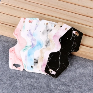 Macro detail of eight marble-patterned jewelry display cards for headband packaging
