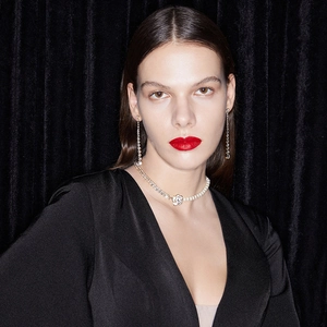 Close-up of elegant camellia flower necklace with pearls and long fringe tassel earrings