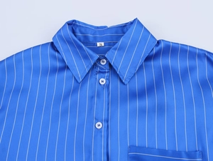 Détail d'une chemise de pyjama en satin à rayures bleues montrant le col et la taille S