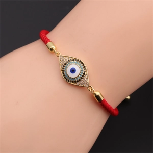 Detailed shot of an adjustable red woven evil eye bracelet with sparkling cubic zirconia