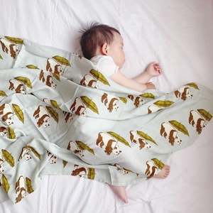 Detail of breathable bamboo cotton muslin baby swaddle with green panda pattern print