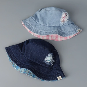 Detail of denim bucket hats showing frayed holes and pink plaid lining textures