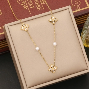 Gold-finish flower pendant necklace with pearls and zircon in a beige jewelry box