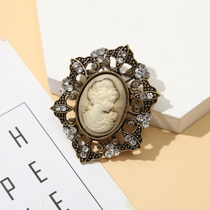 Macro detail of vintage relief lady brooch with bronze alloy filigree and rhinestones