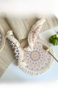 Detail of round boho cotton linen placemat with tassels and ethnic geometric patterns