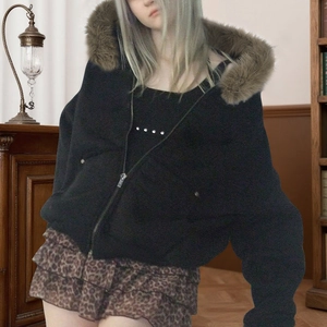 Détail d'une veste noire à capuche avec col en fausse fourrure et texture en tissu tissé