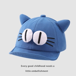 Detailed close-up of blue baby baseball cap featuring cartoon cat ears and big eye embroidery