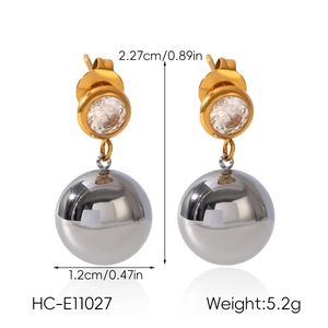 Detail view of two-tone drop earrings with gold ring and silver polished spheres