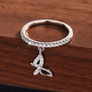 Macro shot of silver butterfly pendant ring with sparkling cubic zirconia on wood