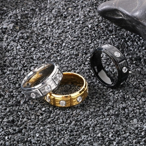 Detailed view of silver, gold, and black 8mm titanium rings with inlaid cubic zirconia