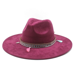 Close-up of wide brim suede fedora featuring ethnic woven band and colorful tassels