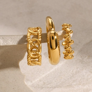 Three-piece set of gold stainless steel rings featuring chain, smooth, and textured designs