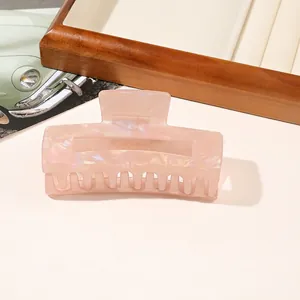 Macro detail of rectangle PVC hair claw clip with pink pearlescent marble texture finish