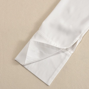 Gros plan du poignet de chemise blanche montrant la texture fine et les coutures nettes