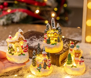 Close-up of lighted Christmas resin gingerbread houses with Santa and snowman figurines