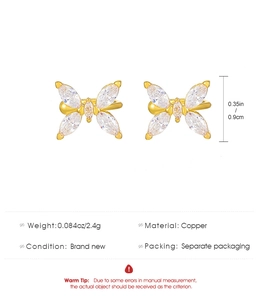 Detail view of copper butterfly ear clips with cubic zirconia stones showing 0.9cm size