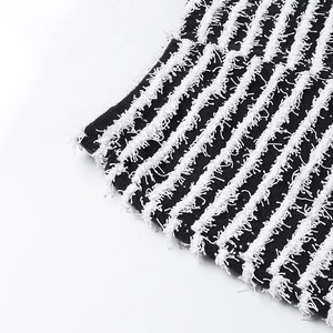 Gros plan détaillé du tissu en maille rayé noir et blanc avec une texture à franges