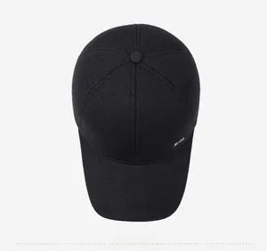 Top down view of black wool baseball cap with soft texture and metallic side logo detail