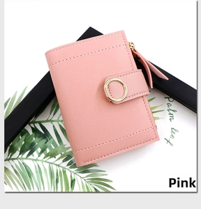 Close-up of pink lychee grain leather wallet with round metal clasp and zip detail