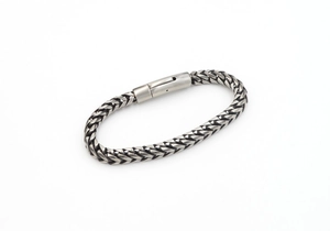 Detailed close-up of a silver dragon scale punk bracelet with a secure plug-in clasp