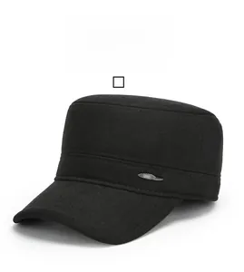 Detail of a black flat top military cap featuring wool fabric and metal side plaque