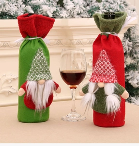 Close-up of knit Christmas gnome wine bottle covers on a festive fireplace mantel