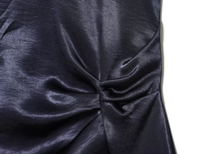 Détail d'une mini robe en satin bleu marine montrant des fronces et une texture soie