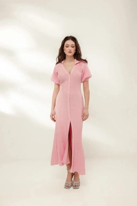 Detail of pink knitted maxi dress showing textured ribbing and button-down v-neckline