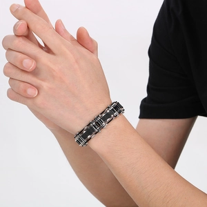 Close-up of men's biker style steel mesh bracelet with black and silver chain link