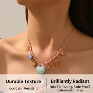 Detail of woven pink cord necklace featuring a blue heart pendant and floral charms