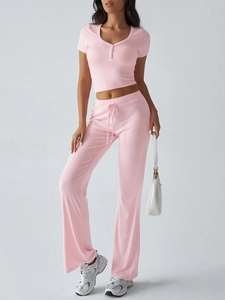Dettaglio del set in maglia rosa Y2K con crop top a bottoni e pantaloni a zampa