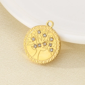 Gold stainless steel Tree of Life pendant with sparkling crystals on a textured fabric