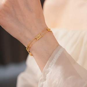 Macro detail of vintage hollow flower gold bracelet with double layer chain on wrist