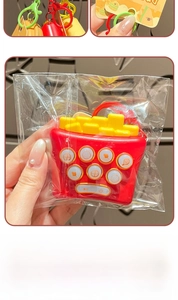 Détail macro du porte-clés jeu de frites rouges avec boutons d'icônes alimentaires colorés