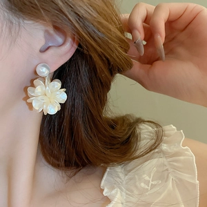 Nahaufnahme eines französischen Kamelien-Perlenohrrings mit eleganten weißen Blütenblättern