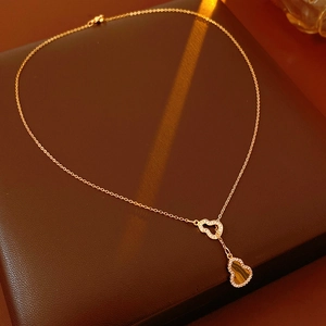 Close-up of heart-shaped tiger eye pendant on a gold chain with zirconia details