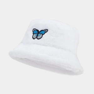 Detailed view of plush white bucket hat featuring blue butterfly embroidery patch