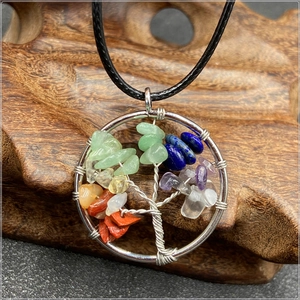 Macro view of handmade silver wire tree of life pendant with colorful chakra stones
