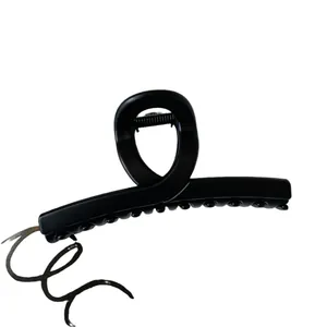 Matte black oversized hair claw clip featuring non-slip teeth in a minimalist cross design