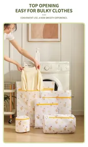 Detail showing hand placing a knit sweater into a fine mesh laundry bag with bear print