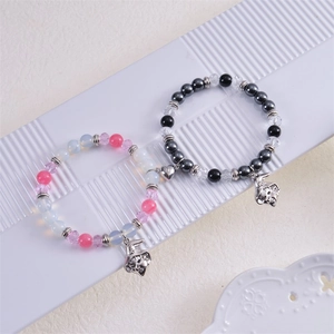 Detail of magnetic heart couple bracelets with wizard hat charms and crystal beads