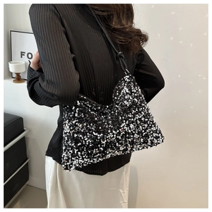 Détail des paillettes argentées scintillantes et de la bandoulière noire du sac à main