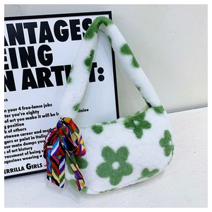 Detailed view of white plush handbag with green floral patterns and colorful scarf accessory