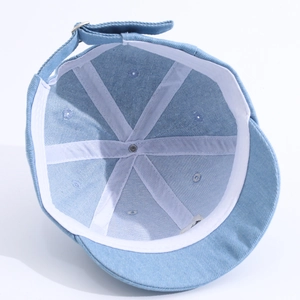 Détail intérieur d'une casquette en denim pour bébé avec coutures et boucle en métal