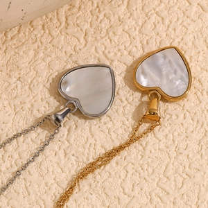Vue détaillée de pendentifs en forme de cœur avec incrustation de nacre blanche et or