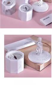 Detailed view of handmade soy candle in marble hexagon jar with decorative angel lid