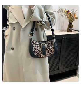 Detail of leopard print shoulder bag with gold metal buckle and knotted strap design