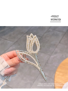 Detailed view of tulip hair claw clip with inlaid pearls and rhinestones being held
