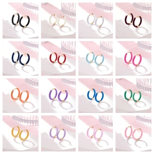 Macro detail of sixteen colorful enamel hoop earrings on a minimalist display