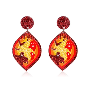 Macro shot of Halloween ghost and bat pattern earrings on glittery red acrylic
